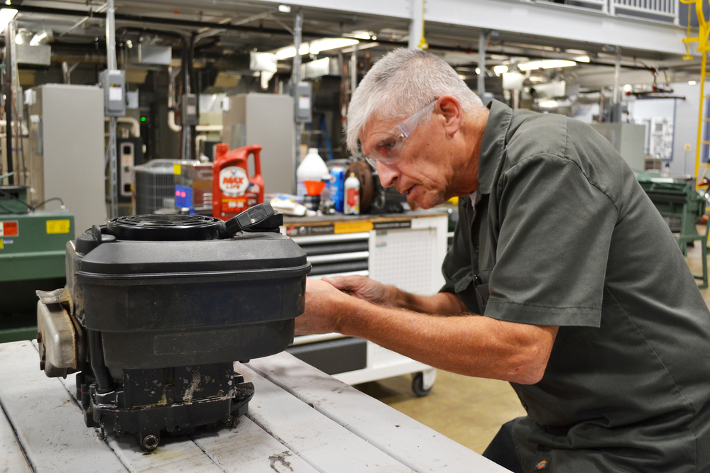 man repairing small engine